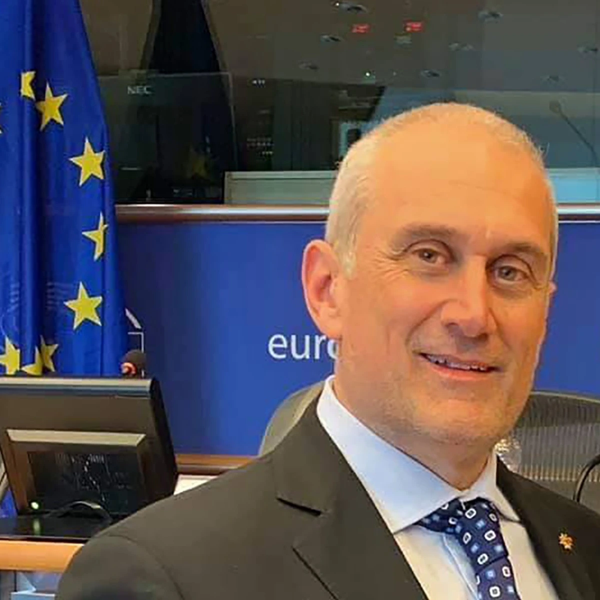 Roberto Taroni presso il Parlamento europeo, con la bandiera dell’Unione europea
